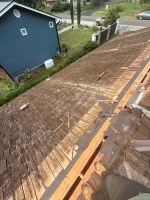 Worn cedar shake roof partly torn off