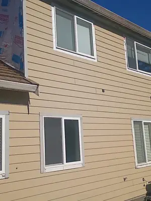 New tan lap siding with trimmed windows
