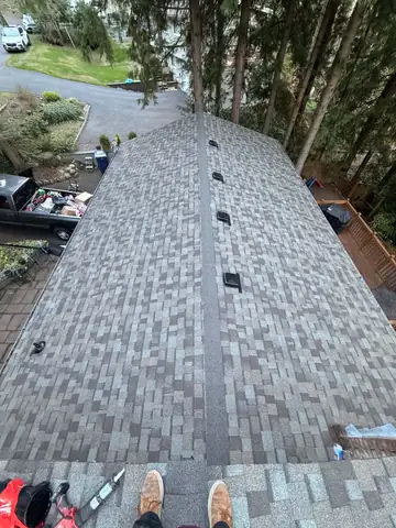 Finished gray shingle roof with new vents, seen from the ridge