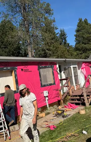 Crew installing house wrap on a single-story home